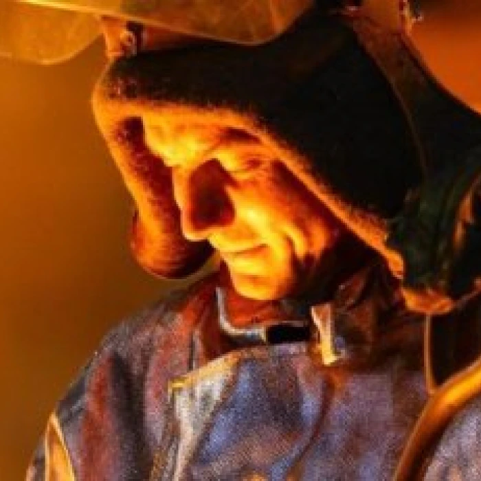 Steelworker illuminated by molten metal glow