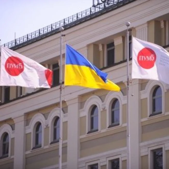 Ukrainian flag and PUMB bank flags on a building