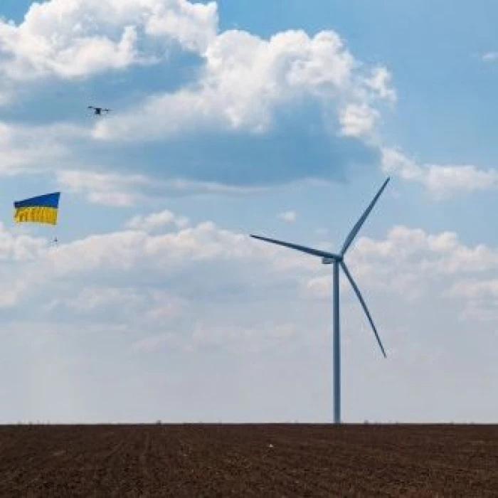 Wind turbine with Ukrainian flag in the sky